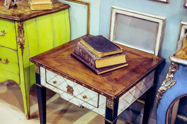 Muebles retro ricos y caros y libros antiguos que yacen en él - p —  Fotos de Stock