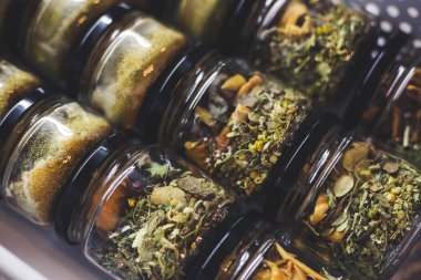 Yükselen enerji için aromatik ayurvedik bitkilerle dolu şeffaf cam kavanozlar.