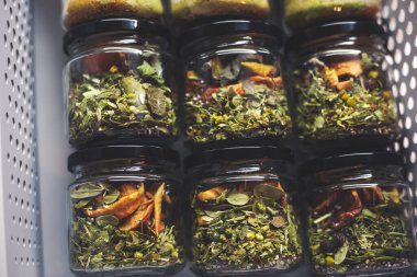 Yükselen enerji için aromatik ayurvedik bitkilerle dolu şeffaf cam kavanozlar.