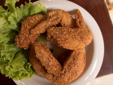 Kızarmış tavuk beyaz tabakta üzerinde ahşap bir masa ayarla