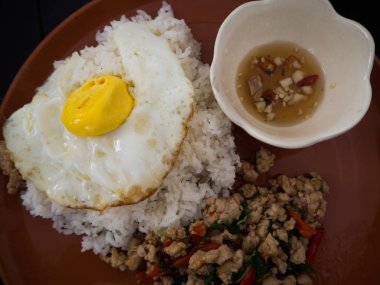 Kızarmış fesleğen tavuk ve pilav ile kızarmış yumurta.