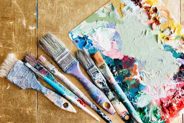Spazzole con tavolozza sullo sfondo creativo. Elemento colorato . — Foto Stock