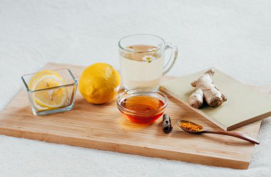 Bitkisel çay papatya çiçeği, zerdeçal ve ballı bir ahşap tahta üzerinde. Zencefil ile sıcak içecek tedavisinde. Halk ilaçları yatakta tedavi.