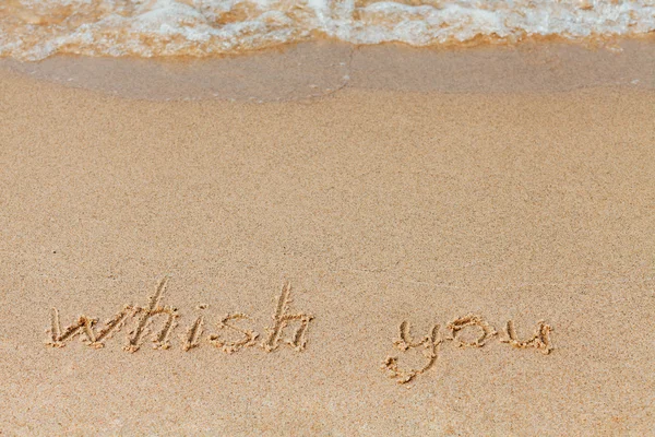 Desejo você - a inscrição na praia de areia com uma onda suave . — Fotografia de Stock
