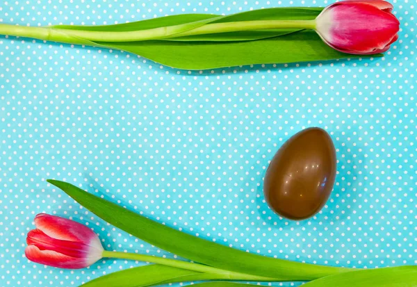 Два ярких цветка и шоколадное яйцо — стоковое фото