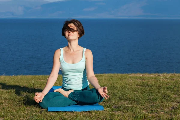 Женщина медитирует на берегу моря — стоковое фото