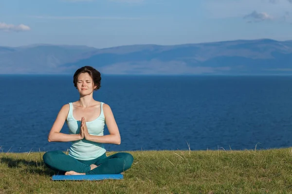 Женщина медитирует на берегу моря — стоковое фото