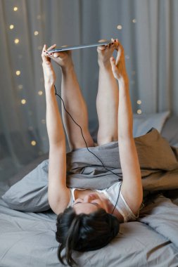 Genç kadın holding tablet bacaklar ile