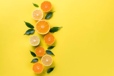 Tropikal meyveli yaratıcı bir arka plan. Portakal, limon, limon, sarı arka planda greyfurt. Düz görünüm kopyalama alanı yatıyordu. Beslenme Konsepti, C vitamini, Hastalık Önleme, Grip