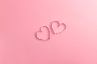 Sevgililer Günü için 14 Şubat 'ta kompozisyon. Zarif pembe arka plan ve kağıttan kesilmiş pembe kalpler. Tebrik kartı. Düz konum, üst görünüm, kopyalama alanı.