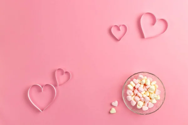 Composition for Valentines Day February 14th. Delicate pink background and a heart cut out of paper. pink heart-shaped marshmallows in a plate. Greeting card. Flat lay, top view, copy space. — Stock Photo, Image