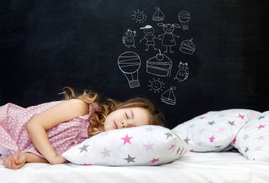 Anaokulu çağındaki sevimli küçük kız yıldızlı bir yastıkta uyuyor. Uyku vakti. Bir çocuğun hayallerini çizmek: kedi yavrusu, tatlı, macera ve arkadaşlık. Boşluğu kopyala