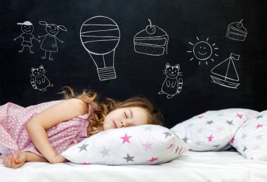 Anaokulu çağındaki sevimli küçük kız yıldızlı bir yastıkta uyuyor. Uyku vakti. Bir çocuğun hayallerini çizmek: kedi yavrusu, tatlı, macera ve arkadaşlık..
