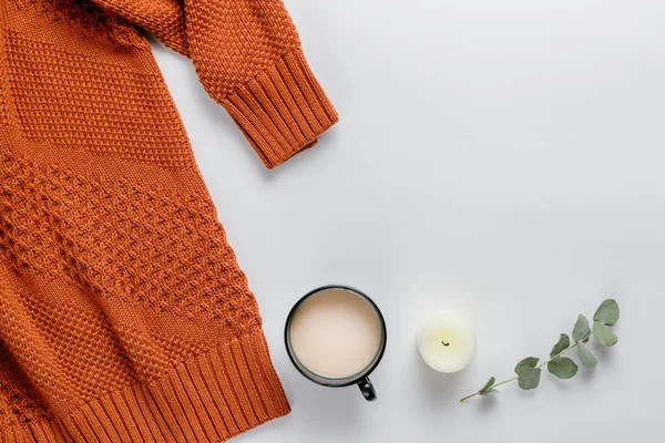 Zimní složení. Oranžový svetr, svíčky a eukalyptová větev na bílém pozadí. Podzim, zimní koncept. Byt ležel, horní pohled, kopírovací prostor — Stock fotografie