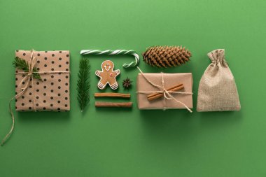 Noel kompozisyonu. Yaratıcı Noel geçmişi. Noel süslemeleri ve köknar dalları yeşil arka planda bir süs ve doku oluşturur. Düz konum, üst görünüm, kopyalama alanı.