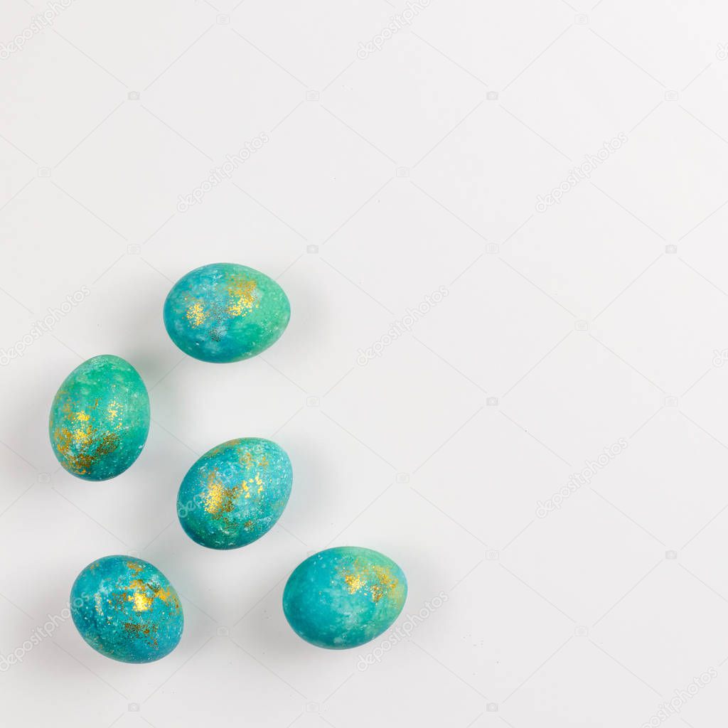 Happy easter card. Stylish minimalistic composition of turquoise with gold easter eggs on a white background. Flat lay, top view, copy space.
