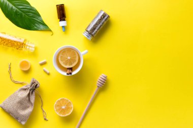 Hastalık konsepti. Bileşik alternatif tıp. Sarı arka planda bitkisel çay, zencefil ve limon. Çocuk sağlığı. Düz yatıyordu. Yukarıdan bak. Boşluğu kopyala