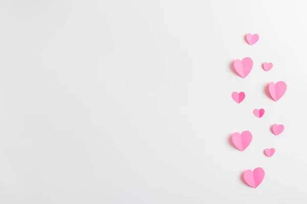 Composição para Dia dos Namorados 14 de fevereiro. Composição delicada de corações rosa feitos de papel sobre um fundo branco. Coração cortado do papel. Cartão de felicitações. Flat lay, vista superior, espaço de cópia . — Fotografia de Stock
