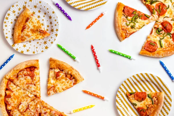 Beyaz arka planda bir pasta için pizza parçaları ve renkli mumlar. Abur cuburla doğum günü. Çocuklar için bir parti. Metin için kopyalama alanı olan üst görünüm. Düz yatıyordu