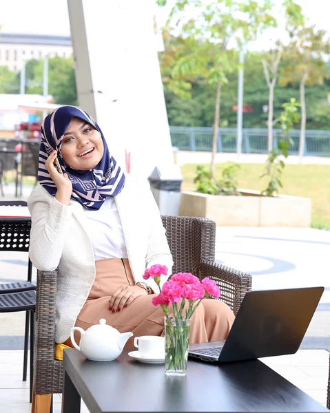 Asiática musulmana mujer pañuelo sentado al aire libre ordenador smartphone —  Fotos de Stock