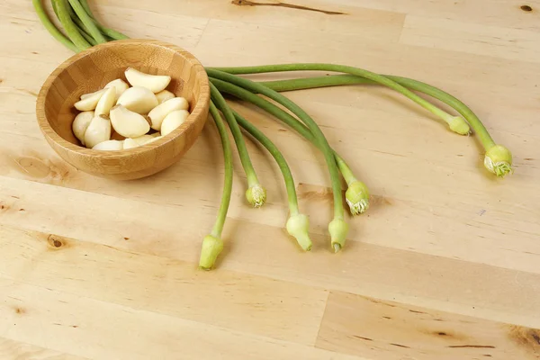 Gemme di fiore di aglio gambo verde su sfondo di legno — Foto Stock