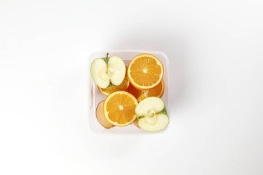 Yeşil kırmızı elma portakalını karıştır. Meyve diliminin yarısı plastik olsun.