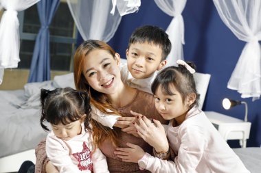 Anne çocuklar kız çocukları mutlu poz veriyor. 