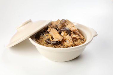 Beyaz arka planda killi seramik kasede mantarlı tavuk pilavı.