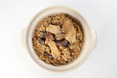 Beyaz arka planda killi seramik kasede mantarlı tavuk pilavı.