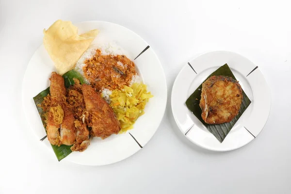 Traditional Malaysian Indian food white rice cabbage vegetable meat deep fried chopped chicken leg topped up with spicy mix gravy white background