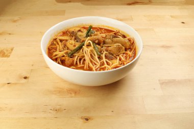 Ahşap zemin üzerinde kızarmış tavuk dilimlenmiş Malezya körili sarı eriştesi.