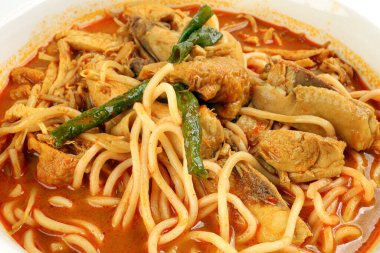 Beyaz arka planda kavrulmuş tavuk dilimli körili sarı erişte.