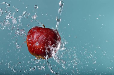 yeşil arka plan üzerinde kırmızı elma suyu damla