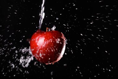 siyah arka plan üzerine su içinde elma