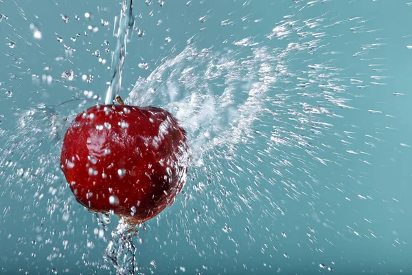 Red apple in water drops on green background — Stock Photo, Image