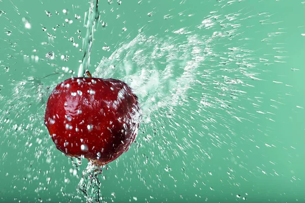 Red apple in water drops on green background — Stock Photo, Image