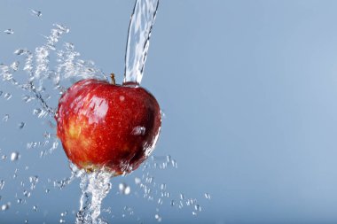 mavi arka plan üzerinde kırmızı elma suyu damla