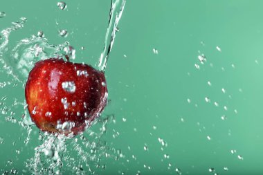 yeşil arka plan üzerinde kırmızı elma suyu damla