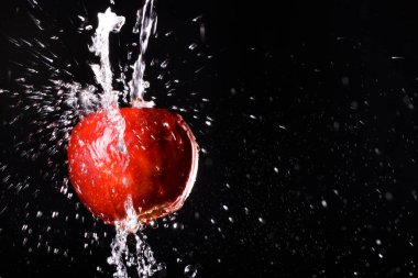 siyah arka plan üzerine su içinde elma