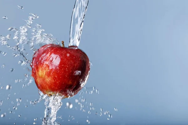 Red apple in water drops on blue background — Stock Photo, Image