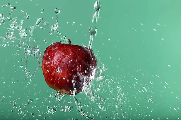 Red apple in water drops on green background — Stock Photo, Image