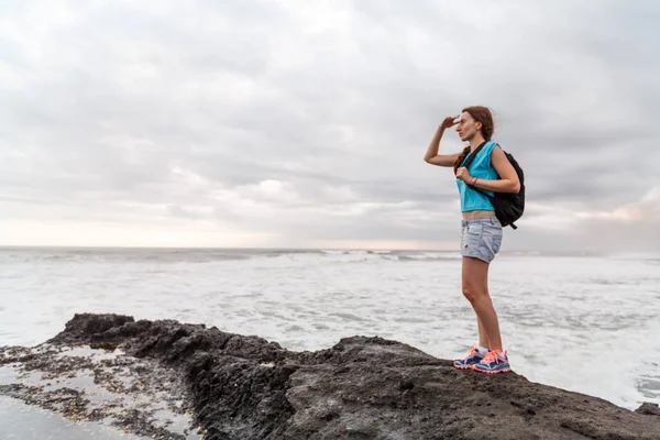 Sırt çantası kıyı şeridi olan kız. Gezgin erkek arka plan plaj deniz manzarası üzerinde.