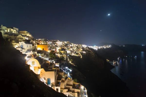 Santorini Island, Yunanistan gece için şehir Oia. Ünlü ve geleneksel evleri ve kiliseleri Caldera, Ege Denizi üzerinde mavi kubbeler ile