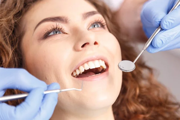 Dentista examinando los dientes de un paciente en el dentista — Foto de Stock