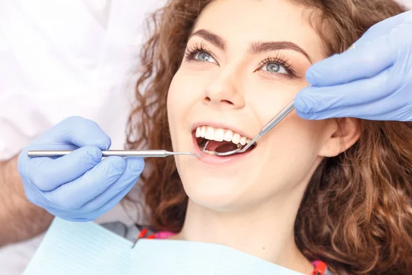 Dentist examining a patient's teeth in the dentist — Stock Photo, Image