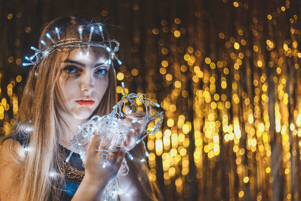 Beautiful young woman with garlands on face and body
