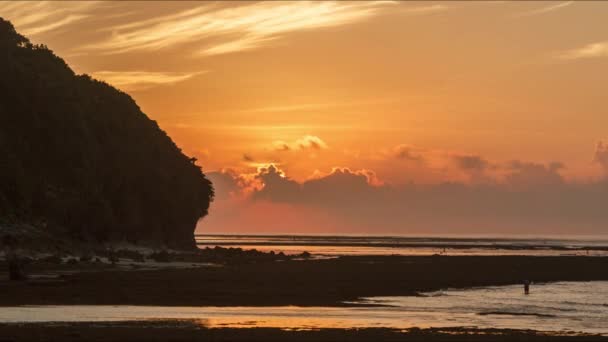 พระอาทิตย์ขึ้นบนชายหาดเขตร้อนที่สวยงามบาหลีบนภูเขาพื้นหลังท้องฟ้าเมฆและทะเลบนเส้นขอบฟ้า บาหลี อินโดนีเซีย 4K TimeLapse — วีดีโอสต็อก