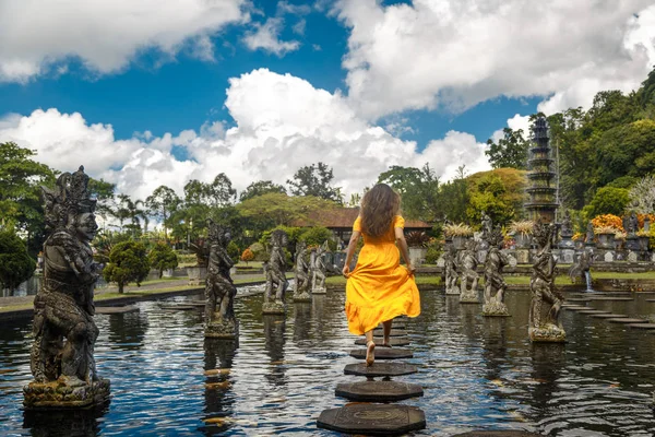 Kadın sarı elbise Gezgin içinde su palace Tirta Gangga, Bali, Endonezya