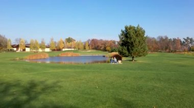 Parktaki yeşil çimlerin üzerinde piknik yapan bir erkek ve kadının hava aracı görüntüsü. Salınan Model