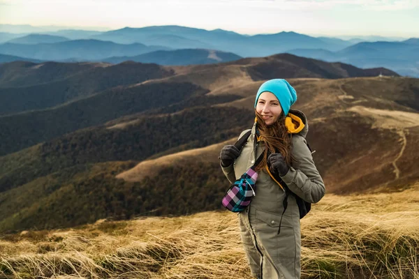 Mujer la parte superior del montaje y mirando un hermoso paisaje. Mujer con mochila logrando la parte superior disfrutando de la luz del sol . — Foto de Stock